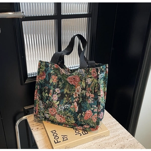Close-up of vintage floral jacquard tote bag on a cookbook with marble background