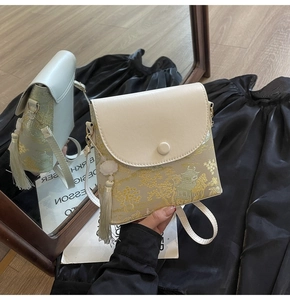 Détail d'un sac élégant avec motif de paysage vert et pendentif à pampille verte