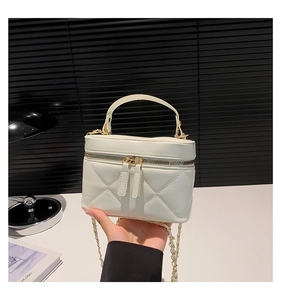 Detail of white quilted mini bag with double zipper and golden chain strap for women