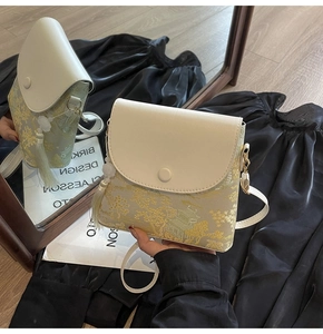 Détail du sac seau blanc avec broderies chinoises dorées, glands et fine bandoulière