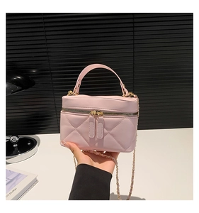 Detail of pink quilted leather vanity bag with double zipper and gold chain strap