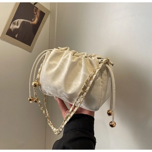 Detailed view of cream leather cloud bag with gold drawstring beads and chain strap