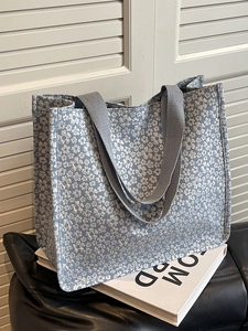 Blue floral canvas tote bag with white flower pattern and grey durable woven handles