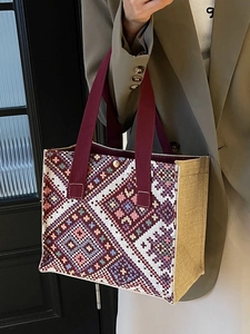 Bohemian style ethnic tote bag with geometric pattern and burgundy handles shown by model