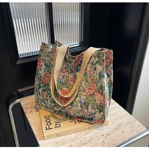 Detail of jacquard floral tote bag with sturdy woven straps on a marble surface