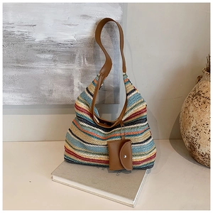Detail of multi-colored striped woven tote with brown leather strap and mini purse