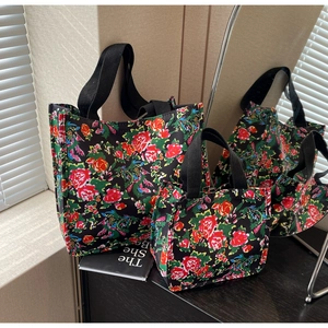 Détail des grands et petits sacs fourre-tout avec imprimé floral vif et anses noires
