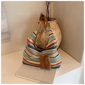 Detail of colorful striped woven tote bag with brown leather strap and mini pouch