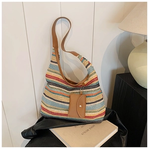 Detailed shot of multi-color striped woven tote with brown leather strap and mini pouch