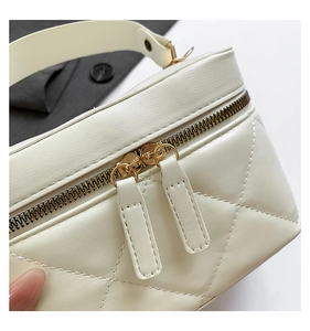 Detail of creamy white quilted handbag featuring premium PU leather and golden zippers