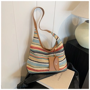 Detail showing colorful rainbow stripe knit texture and leather strap with mini coin purse
