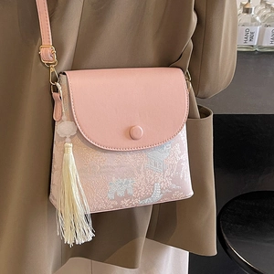 Sac seau rose avec broderie traditionnelle et détail de pompon blanc élégant