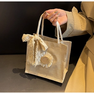 Gros plan du sac en lin avec marguerite, nœud en dentelle et poignées en coton doux