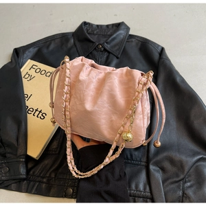 Detail of pink pleated cloud bag with golden chain strap and drawstring closure