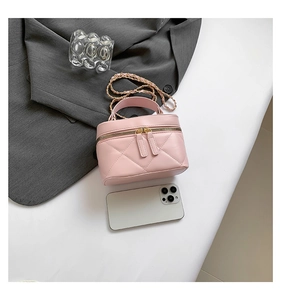 Pink quilted mini bag with golden chain strap shown next to phone for scale