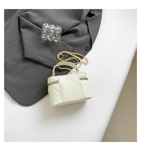 Detail of cream quilted mini bag with gold chain strap and dual zipper closure