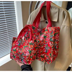 Détails de sacs cabas en toile rouge de deux tailles avec motifs floraux chinois traditionnels