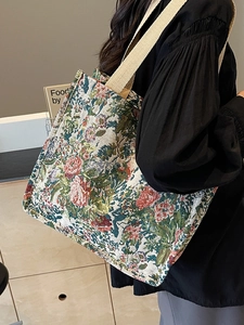 Ethnic floral jacquard tote bag with wide straps shown in a 45-degree model shot