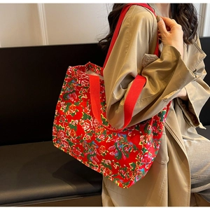 Detailed view of canvas tote bag with traditional Chinese floral pattern and red straps