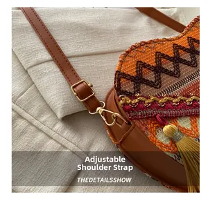 Detail of adjustable leather shoulder strap and golden metal buckle on woven crossbody bag