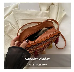Detail showing inner capacity and colorful tassel embroidery of the woven crossbody bag