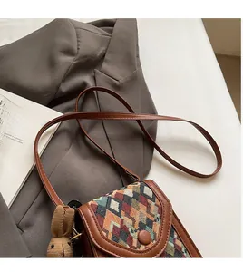 Vertical plaid crossbody phone bag featuring brown leather trim and a knit bunny charm