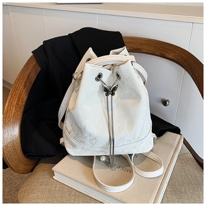 Detail of white bucket backpack with metallic butterfly drawstring buckle and chain