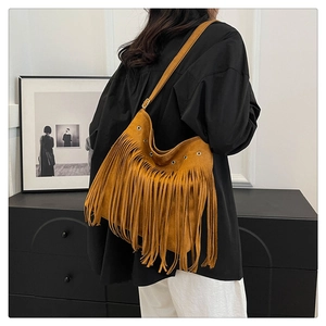 Dettaglio borsa a tracolla boho in camoscio marrone con frange e finiture metalliche