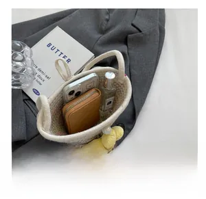 Internal capacity of woven crossbody bag with phone, cardholder, and perfume