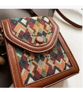 Detailed shot of bohemian style vertical crossbody bag featuring colorful geometric woven fabric
