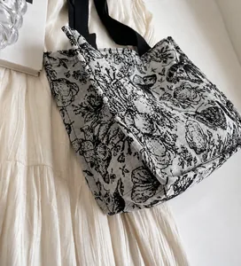 Gros plan sur l'imprimé floral vintage noir et blanc du grand cabas en toile