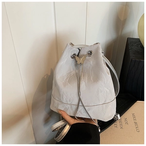 Detailed view of the silver butterfly clasp and marble texture on white bucket bag