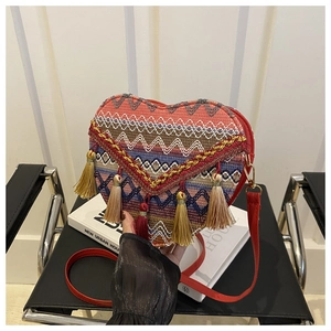 Detailed view of handmade woven heart bag with colorful patterns and vibrant tassels