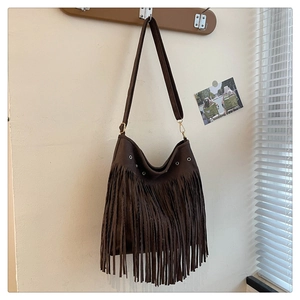Primo piano di una borsa hobo in pelle scamosciata marrone con frange e gancio