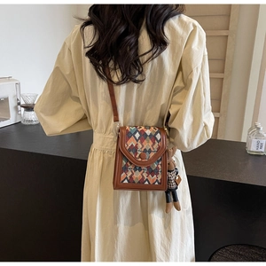 Detailed view of vintage crossbody bag featuring woven geometric pattern and cute bunny charm