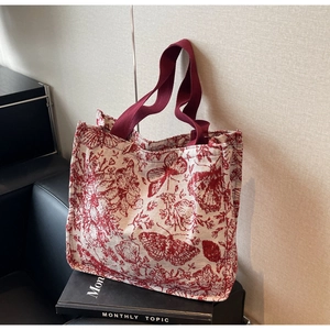 Detail of red toile de jouy canvas tote bag with butterfly pattern and burgundy strap