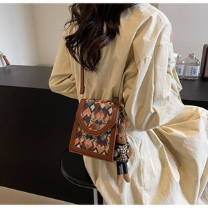 Vertical crossbody bag with colorful geometric woven pattern and cute rabbit charm detail