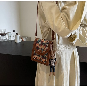 Vertical cross-body bag with vintage geometric woven flap and bunny pendant detail