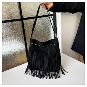 Dettaglio borsa a tracolla in pelle scamosciata nera con occhielli e lunghe nappe boho