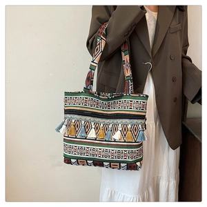 Close-up of ethnic tote bag with colorful geometric patterns and decorative tassels