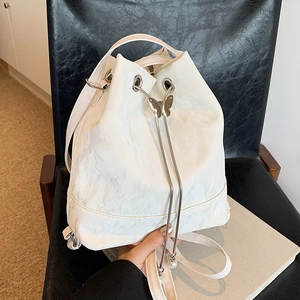 White bucket backpack with textured finish, drawstring closure and butterfly pearl accents