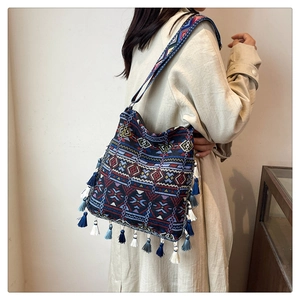 Detail of bohemian tote bag with ethnic embroidery and tassels on adjustable strap