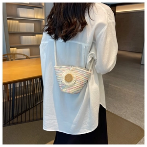 Detailed back view of a mini woven straw bag with sunflower and pearl buckle on model