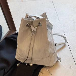 White bucket backpack with pleated texture, silver butterfly buckle and pearl drawstring