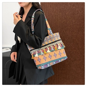 Detail of bohemian tote bag featuring colorful fringe tassels and geometric woven patterns