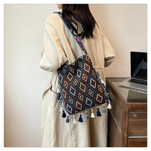 Detail of bohemian tote bag with colorful geometric patterns and blue fringe tassels