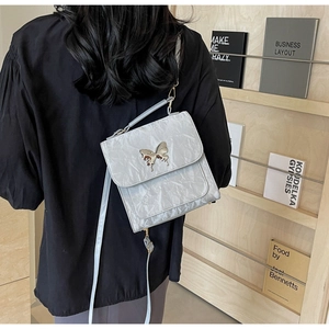 Sac bandoulière gris argenté à texture froissée avec boucle papillon en métal élégante