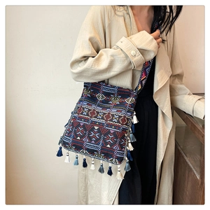 Detail of bohemian woven tote with colorful geometric patterns and long tassels on side