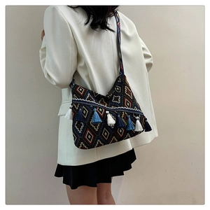 Ethnic shoulder bag with colorful tassels and geometric weave pattern on model