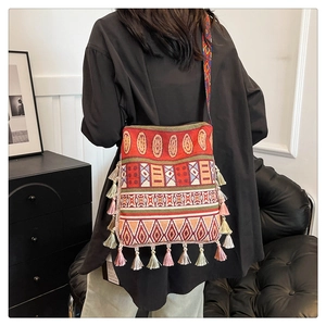 Detailed back view of large bohemian tote with vibrant tribal patterns and fringe